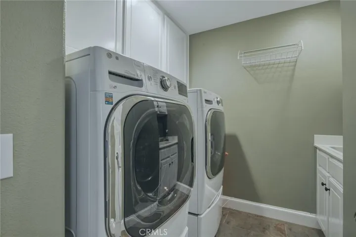 Laundry room with built-in cabinetry, utility sink, and convenient storage space for everyday household needs