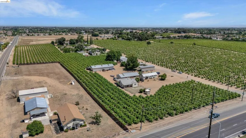 Expansive agricultural property featuring multiple cultivated fields, scattered residential structures, and various outbuildings