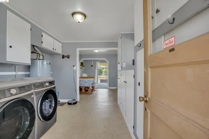 Utility room featuring overhead cabinetry, a water heater, and a built-in counter surface