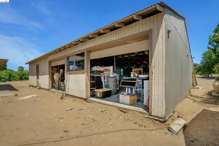 Detached auxiliary building featuring two roll-up doors, a side entry door, and a horizontal sliding window