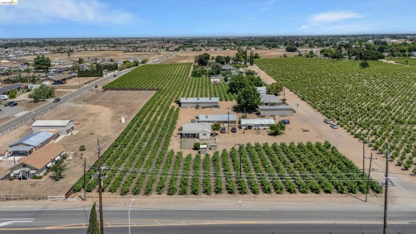 Expansive agricultural property featuring multiple cultivated fields and several structures