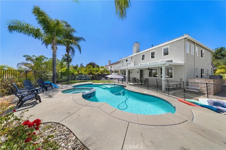 Resort-Style Backyard With Sparkling Pool, Spa, And Palm Tree Accents