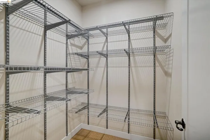 Walk-in closet featuring extensive wire shelving, multiple storage levels, and a crisp white baseboard trim