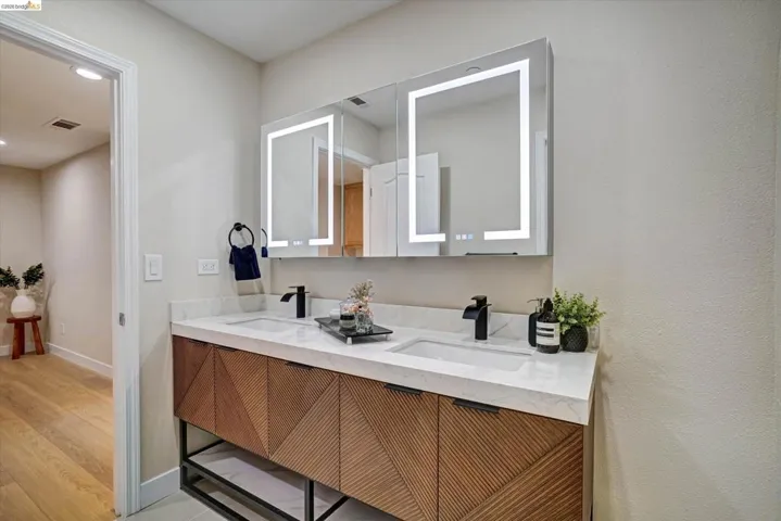 Dual vanity with integrated sinks, white countertop, and contemporary black faucets