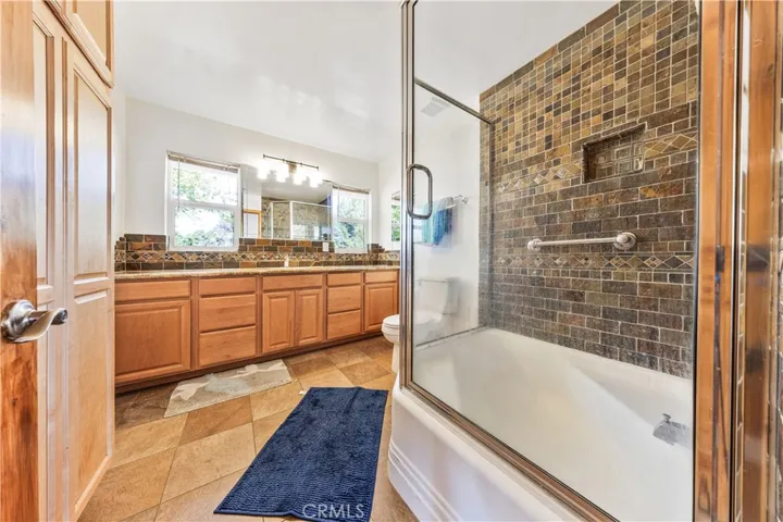 Spacious Bathroom with granite counter tops, Abundant storage and decorative tile surround.