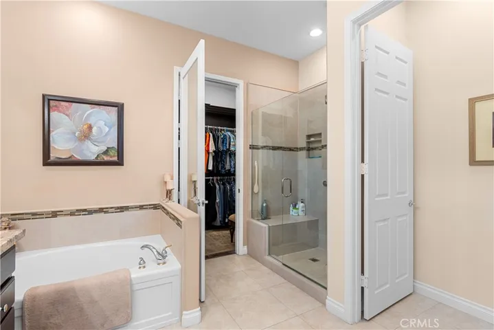 Custom Tiled Walk-in Shower with Bench Seat and Oval Bath Tub in Primary Bath