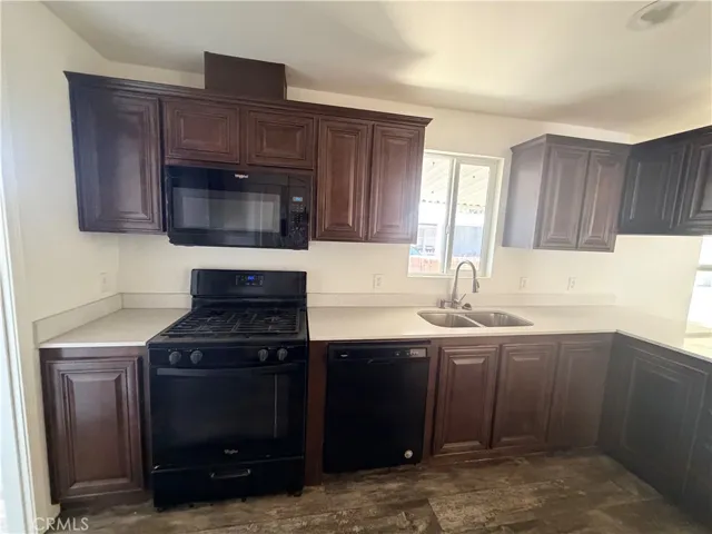 Full kitchen shot of stove and sink.