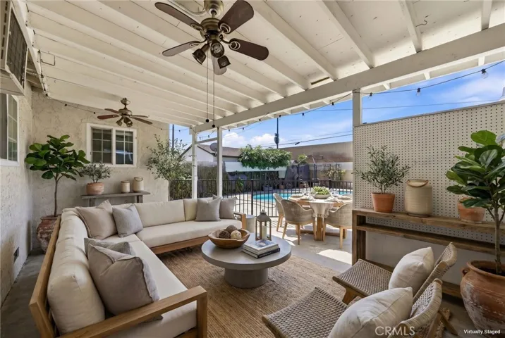 Virtually staged covered patio showcasing seamless indoor-outdoor living with views overlooking the pool, ideal for entertaining and relaxation.