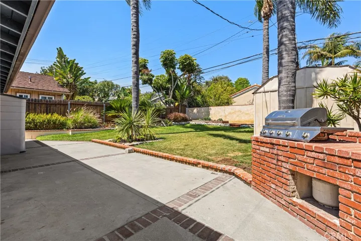 Large grassy backyard with built in barbeque.