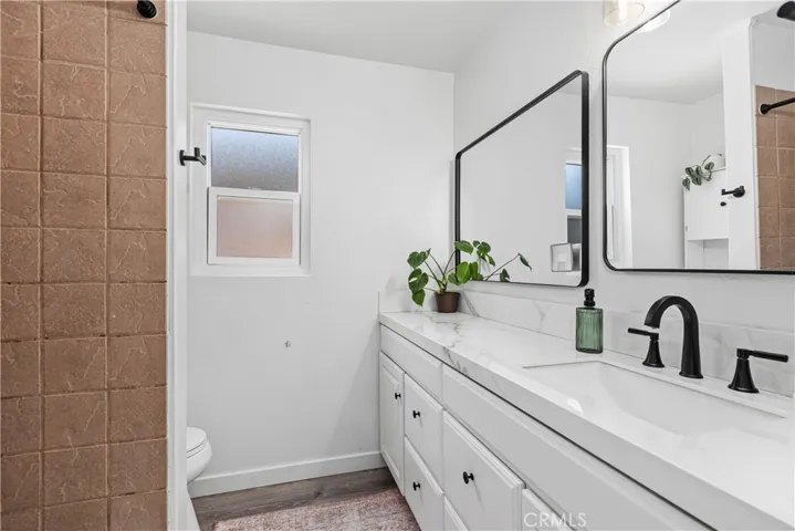 Secondary full bath with new flooring, counters, mirrors, hardware and new Kohler toilet.