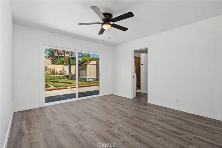 Primary bedroom with new flooring looking out to large grassy backyard.