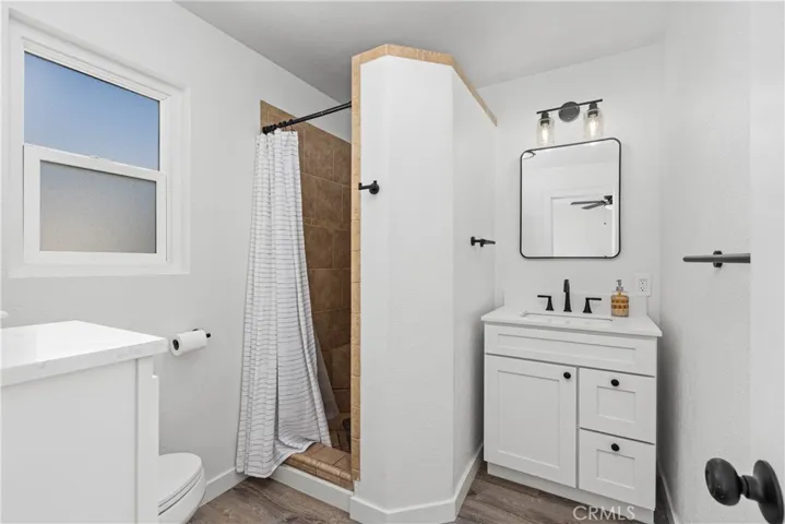 Remodeled primary bath with new flooring, new Kohler toilet, new cabinets, sink and new hardware throughout.