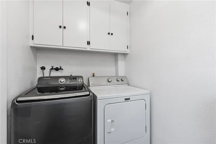 Separate laundry room with storage.