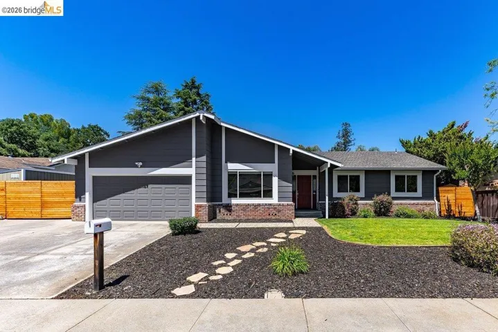 Contemporary ranch-style residence featuring a dark gray exterior with white trim