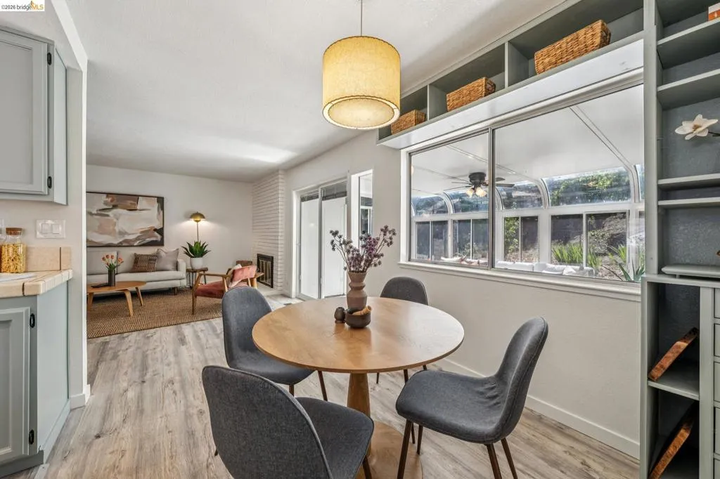 Dining area featuring wood-finish flooring and a contemporary pendant light fixture