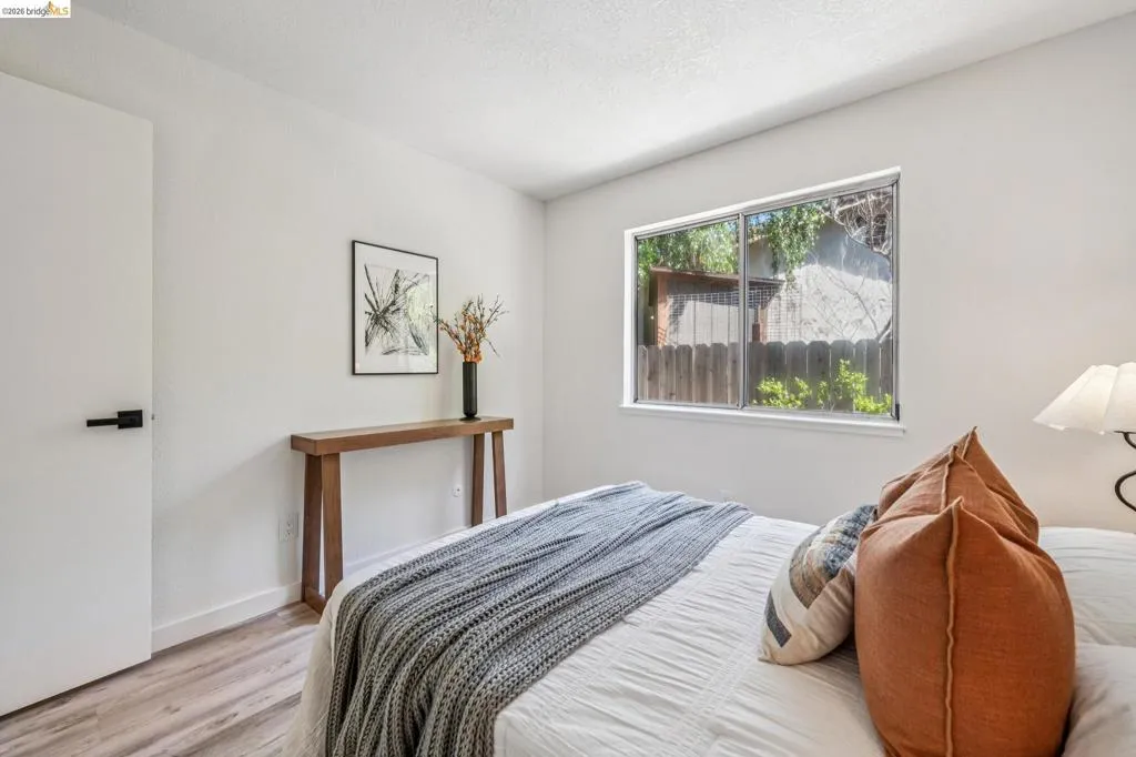 Room featuring white walls, wood-finish flooring, and a single window