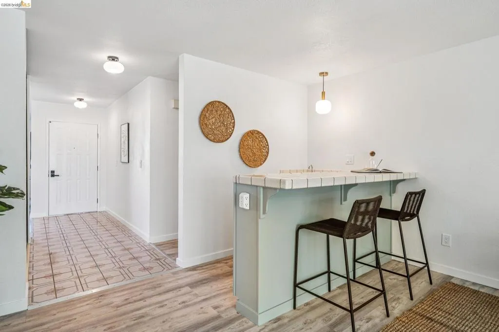 Entryway featuring wood-finish flooring transitioning to patterned tile