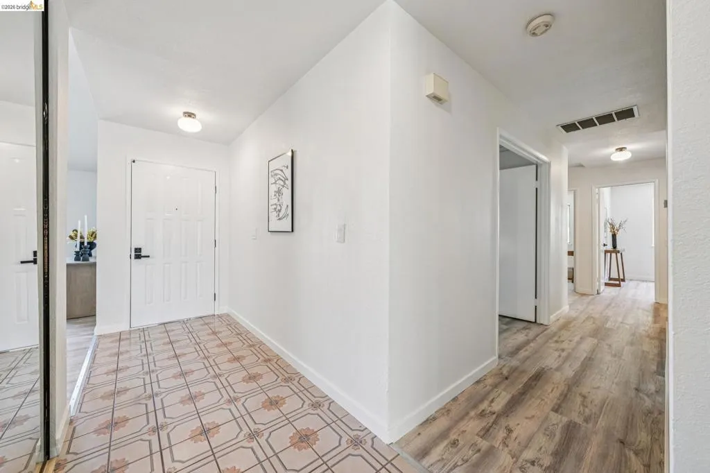 Entryway featuring patterned floor tile, a paneled door with black hardware, and an overhead flush mount light