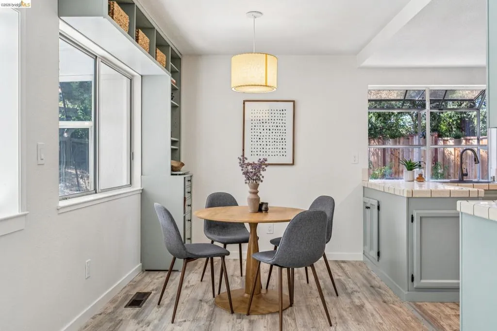 Bright dining area featuring wood-finish flooring and a central pendant light fixture