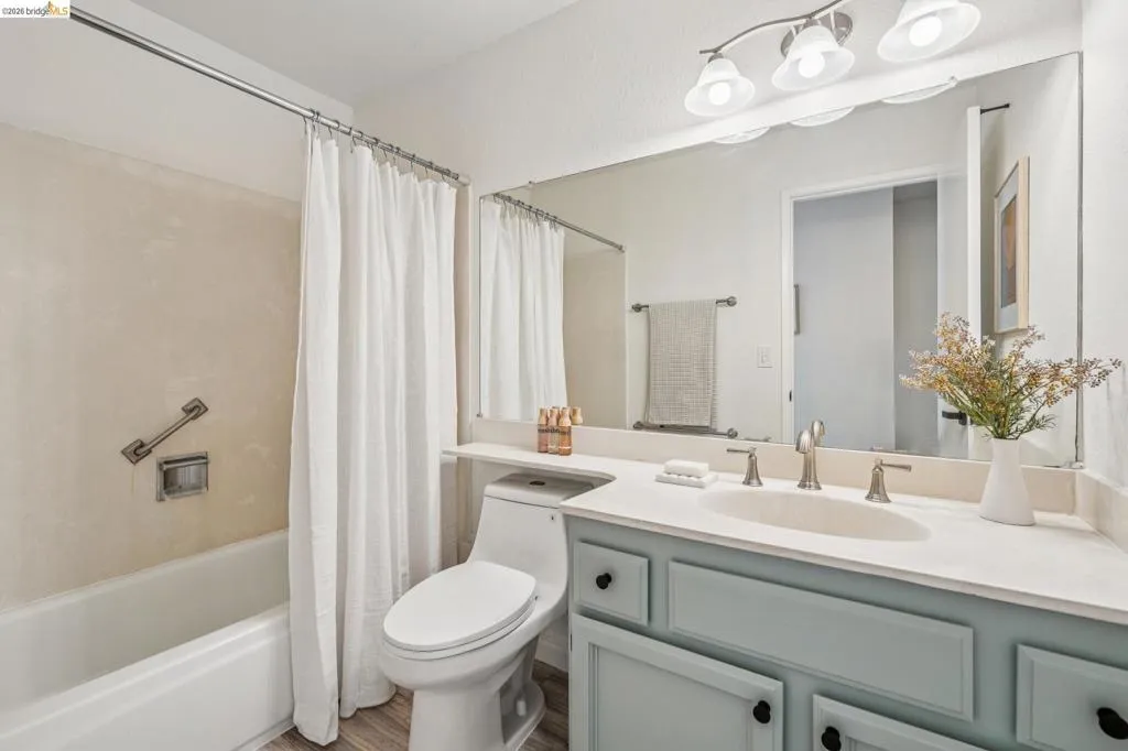 Bathroom vanity with light blue cabinetry, a light-colored countertop, and a built-in sink
