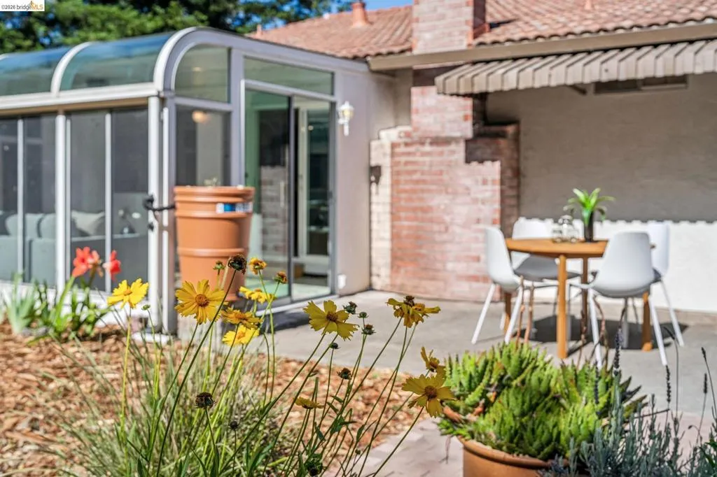 Glass-enclosed sunroom with sliding door entry and a curved roofline
