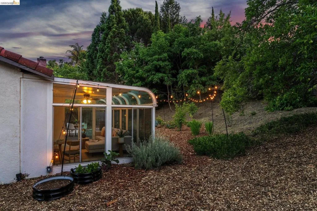 Sunroom addition with curved glass roof, featuring a ceiling fan and recessed lighting