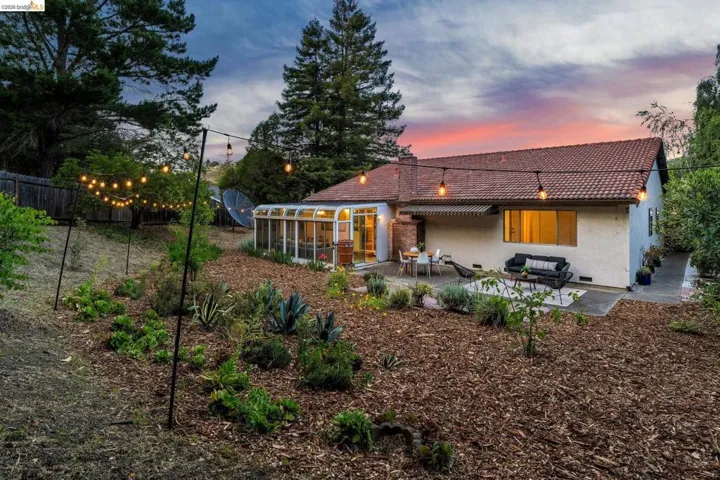 Expansive backyard featuring a dedicated patio, sunroom, and string lighting