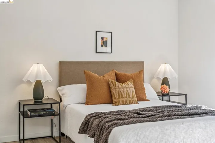 Bedroom with a fabric upholstered headboard and light-toned walls