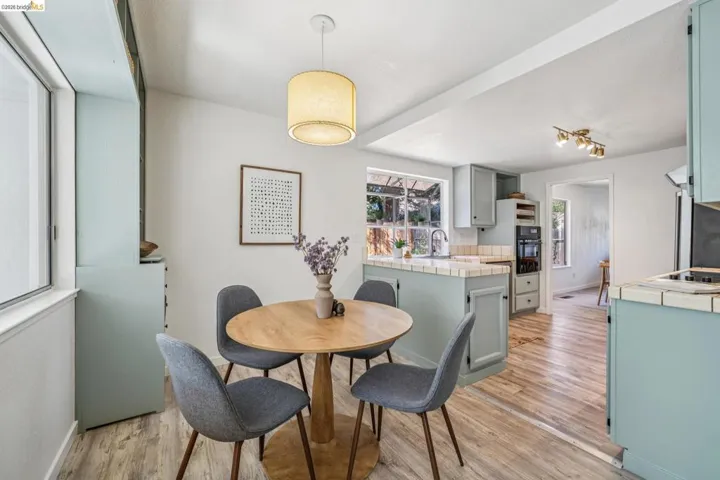 Dining area featuring wood-finish flooring and a drum pendant light fixture