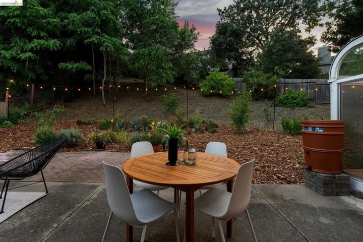 Concrete patio featuring string lighting and a terraced landscape
