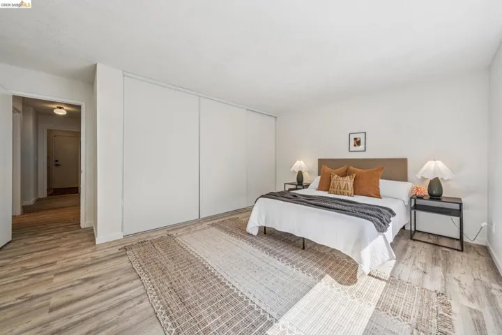 Spacious room featuring wood-finish flooring, white walls, and a recessed ceiling light
