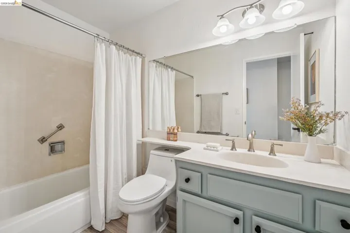 Bathroom vanity with light blue cabinetry, a light-colored countertop, and a built-in sink
