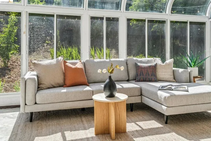Sunroom featuring extensive glass paneling, a curved glass ceiling, and a light-colored woven floor covering