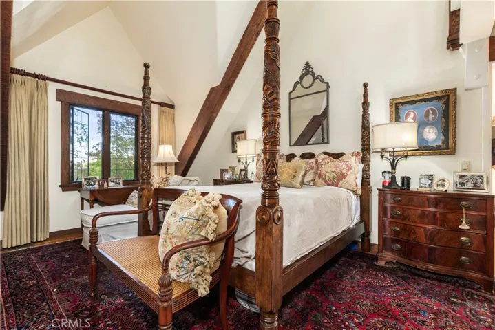 Primary suite boasts vaulted ceilings with large wood beams.