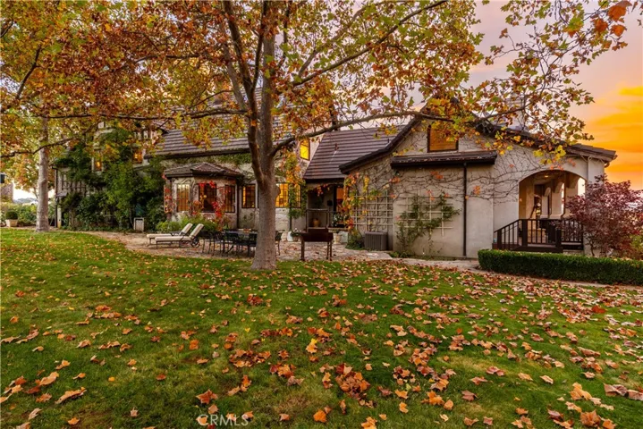 The rear yard is inviting with lush lawns and natural landscape.