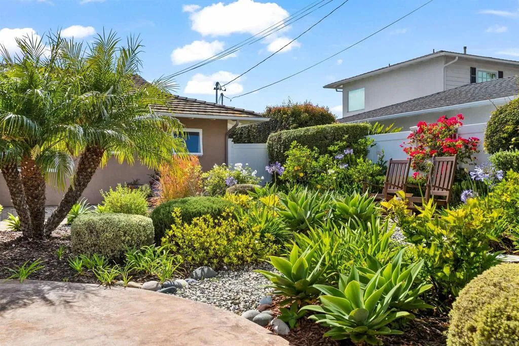 The front yard has a sitting area surrounded by citrus trees, and native and low water plants