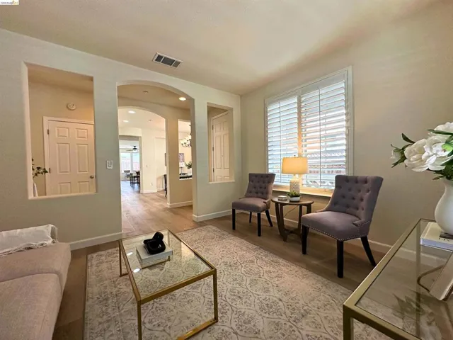Living area featuring wood-finish flooring, an arched entryway, and recessed wall niches