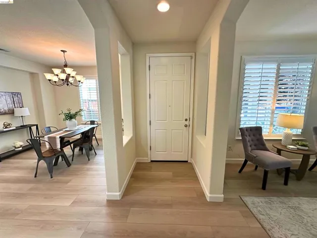 Entryway featuring wood-finish flooring, a paneled front door, and architectural wall cutouts