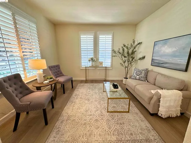 Living area featuring wood-finish flooring, plantation shutters, and recessed lighting