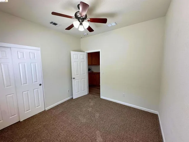 Neutral-toned room featuring textured walls and brown carpet flooring