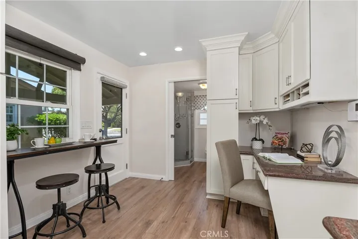 The breakfast nook creates a comfortable place for morning coffee or casual meals, framed by natural light, bamboo window coverings, and views toward the side yard.