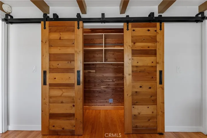 A large cedar-lined closet with custom handcrafted barn doors and an organization system adds both function and character to this flexible bedroom space.