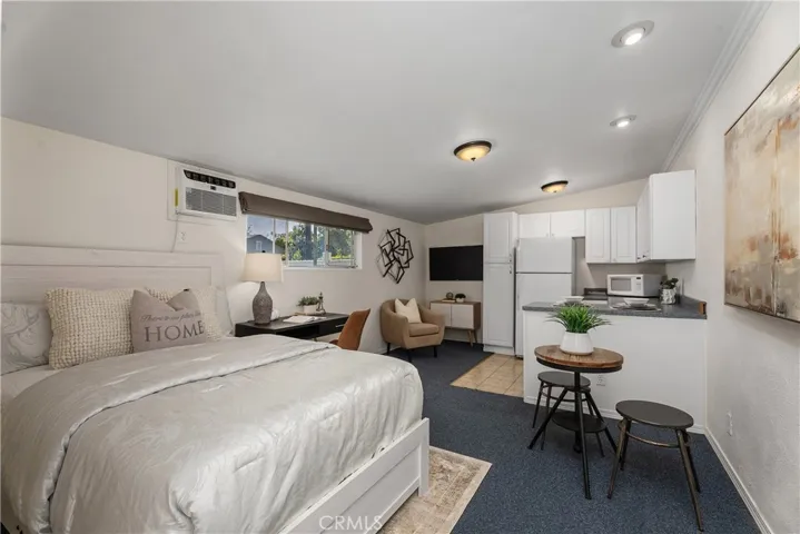 Inside the Junior ADU, the space offers a comfortable seating area, cabinetry for kitchen or recreational use, refrigerator, and window AC — creating a versatile extension of the property.