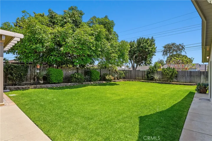 The nearly 8,300 sq ft pool-size lot continues with a spacious grass lawn, professionally maintained flowerbeds, new perimeter wood fencing, and room to imagine future possibilities.