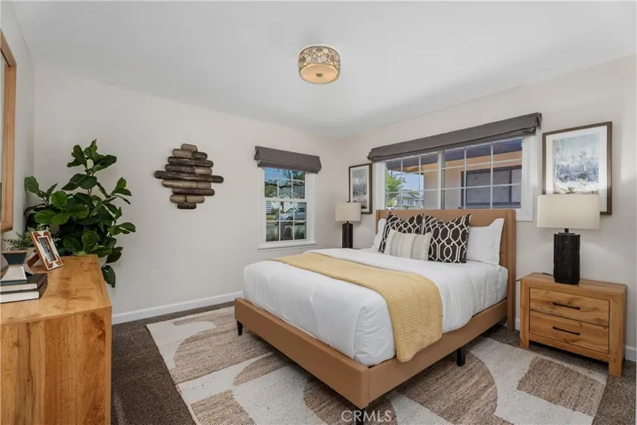 One of the additional bedrooms offers a calm and comfortable setting with newer plush carpeting, closet organization, newer windows, and window coverings.