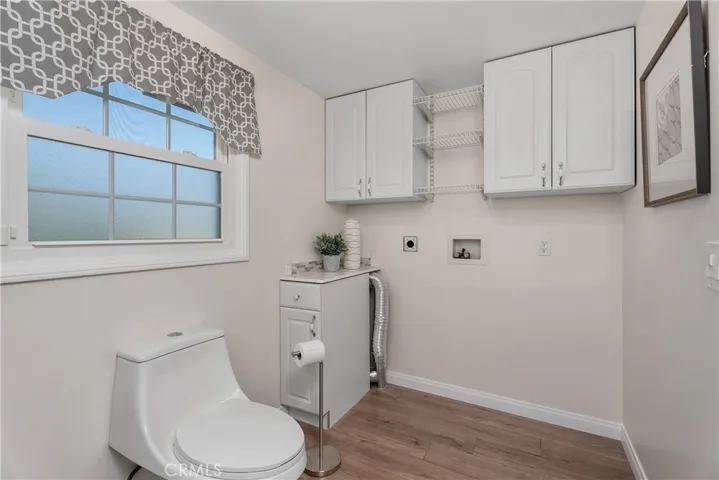 The laundry area is thoughtfully integrated with built-in cabinets, electric dryer hookup, and a clean, updated design that makes this expanded space both practical and polished.