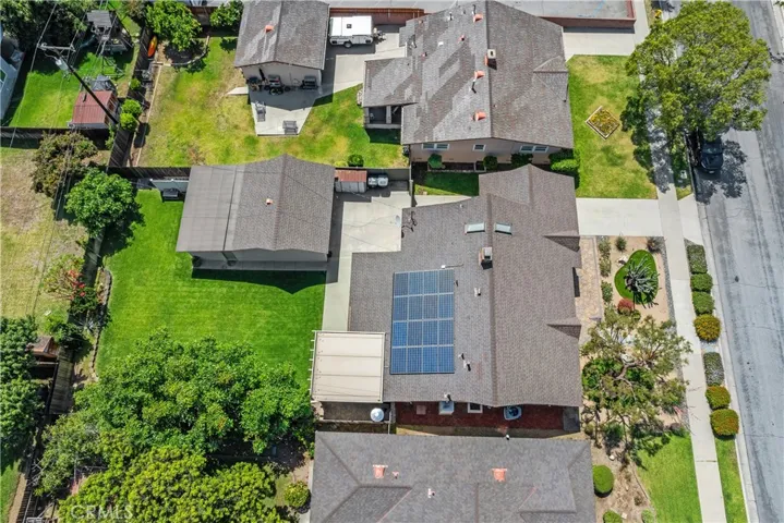 The aerial view highlights the newer roof with 50-year tile, new wood fencing, long gated driveway, detached two-car garage with new garage door, and pool-size lot.