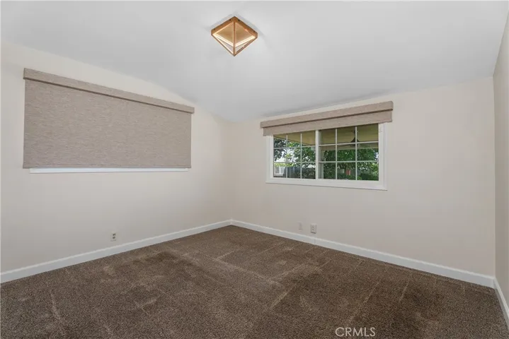 The third main-house bedroom offers another comfortable sleeping space with newer plush carpeting, closet organization, newer windows, and window coverings.
