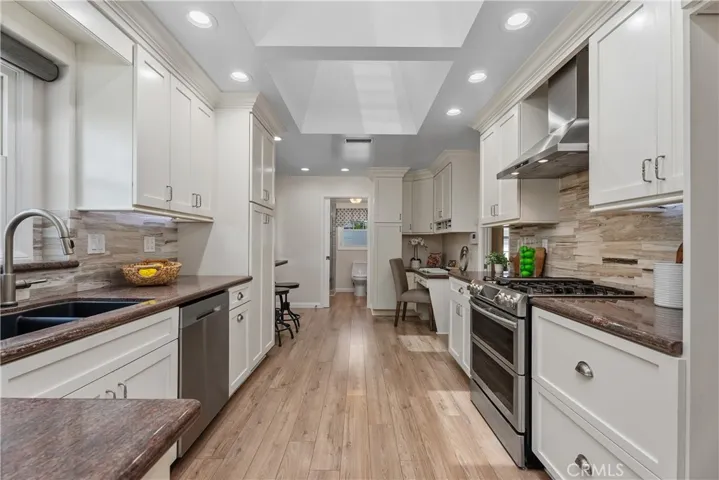 Designed for both cooking and gathering, the kitchen features generous counter space, custom cabinetry, and a durable black granite sink designed to resist scratching or breaking.