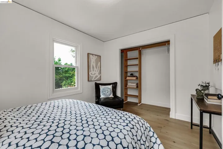 Bright room with a single window, featuring wood-finish flooring